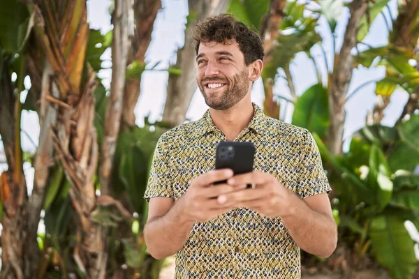 Ung Latinamerikansk Man Ler Säker Med Hjälp Smartphone Parken — Stockfoto