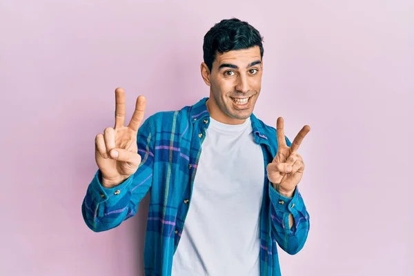 Pohledný Hispánec Neformálním Oblečení Usmívající Kameru Ukazující Prsty Ukazující Znamení — Stock fotografie
