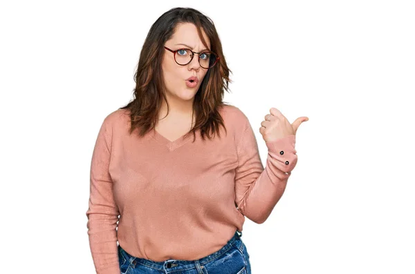 若いプラスサイズの女性を身に着けているカジュアル服や眼鏡驚きポイントで手指で側面に 口を開けて驚くような式 — ストック写真