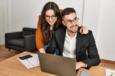 Ofiste çalışırken gülümseyen iki İspanyol iş adamı..