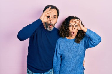 Orta yaşlı bir çift İspanyol kadın ve erkek birbirine sarılıyor ve iyi bir jest yapıyorlar. Şaşırmış bir yüz, parmaklarından bakan gözler. İnançsız ifade. 