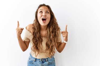 Güzel İspanyol kadın tecrit edilmiş bir şekilde ayakta dururken arka plan şaşkın ve şaşırmış bir şekilde yukarı bakıyor ve parmaklarıyla işaret ediyor ve kollarını kaldırıyordu.. 