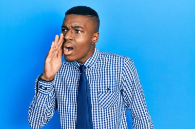 Genç Afro-Amerikalı iş gömleği ve kravat takmış bağırıyor ve ağızdan ağıza bağırıyor. iletişim konsepti. 