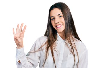 Genç esmer genç iş adamı beyaz gömleği giyer ve parmaklarıyla dört numarayı gösterirken kendinden emin ve mutlu bir şekilde gülümser.. 