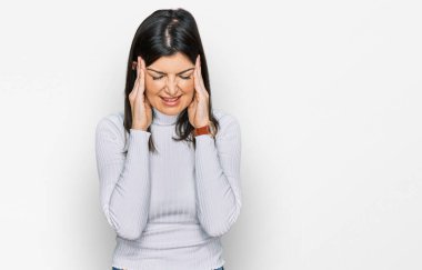 Güzel esmer kadın, elleri kafasında günlük kıyafetler giyiyor, stres yüzünden baş ağrısı çekiyor. migren ağrısı. 