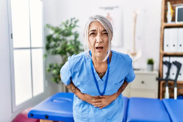 Medelålders Gråhårig Kvinna Bär Sjukgymnast Uniform Läkarmottagningen Med Handen Magen — Stockfoto