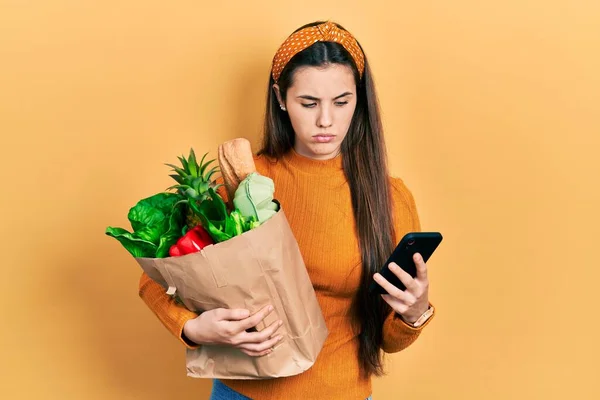 Ung Brunett Tonåring Hålla Väska Med Livsmedel Med Hjälp Smartphone — Stockfoto