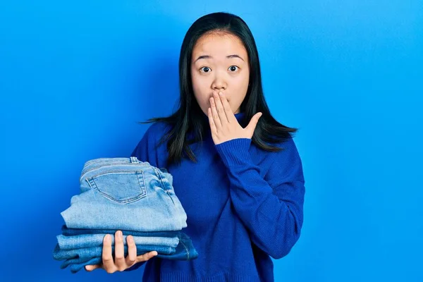 Jeune Fille Chinoise Tenant Pile Jeans Pliés Couvrant Bouche Avec — Photo