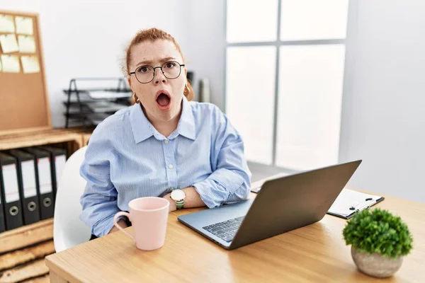 Jovem Ruiva Trabalhando Escritório Usando Laptop Computador Face Choque Parecendo — Fotografia de Stock
