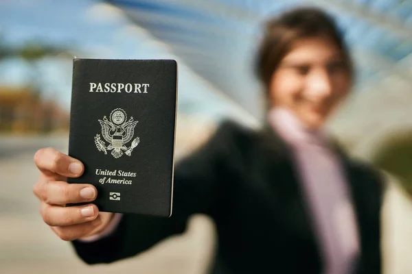 年轻美丽的女商人笑着高高兴兴地在城里持着美国护照 — 图库照片