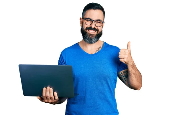 有胡子的西班牙男人用电脑笔记本电脑工作时 面带微笑 面带微笑 大拇指向上翘起 做得很出色 并签了字 — 图库照片