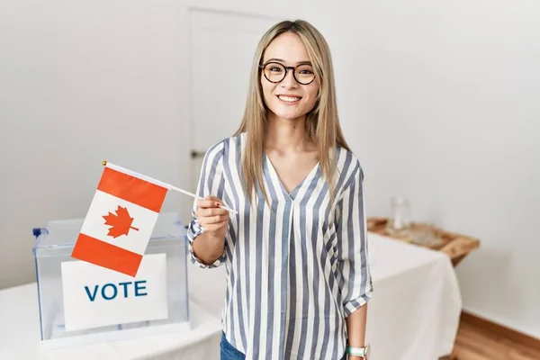 Azjatycka Młoda Kobieta Wyborach Politycznych Trzymająca Flagę Kanady Wyglądająca Pozytywnie — Zdjęcie stockowe