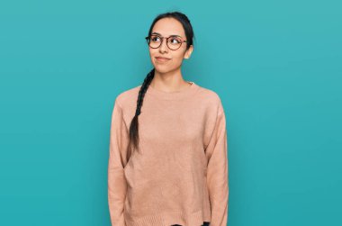 Gündelik kıyafetler ve gözlük takan genç İspanyol kız gülümseyip yan tarafa bakıyor ve düşünüyor.. 