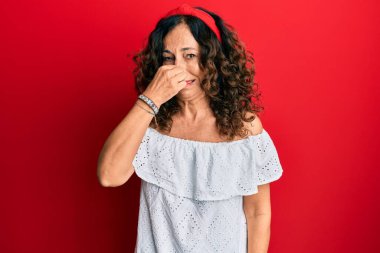 Orta yaşlı İspanyol kadın gündelik kıyafetler giyiyor. Kokuşmuş ve iğrenç bir koku alıyor. Dayanılmaz bir koku. Kötü kokuyor. 