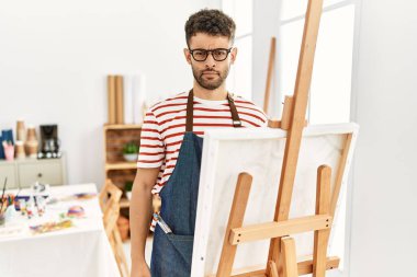 Sanat stüdyosundaki Arap genç adam şüpheci ve gergin, sorun yüzünden surat asıyor. negatif kişi. 