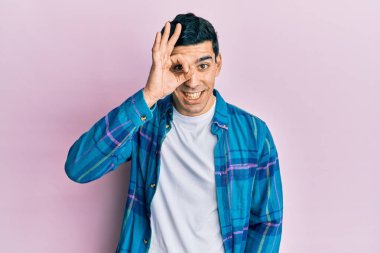 Yakışıklı İspanyol giyinen, sıradan giyinen, el hareketleriyle gülümseyen, mutlu yüzüyle parmaklarının arasından bakan.. 