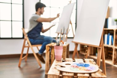 Resim stüdyosunda gülümseyen genç İspanyol ressam..