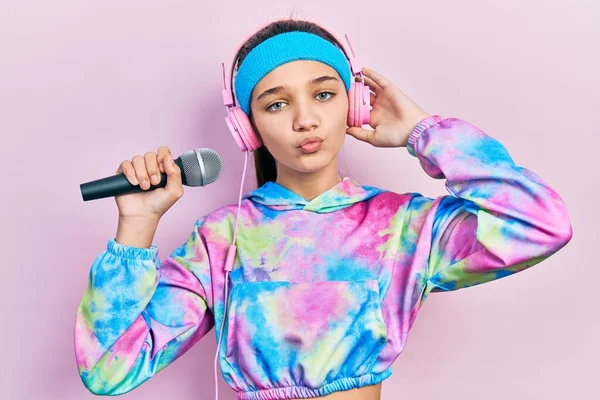 Young Brunette Girl Singing Song Using Microphone Wearing Sportswear Looking — Stock Photo, Image
