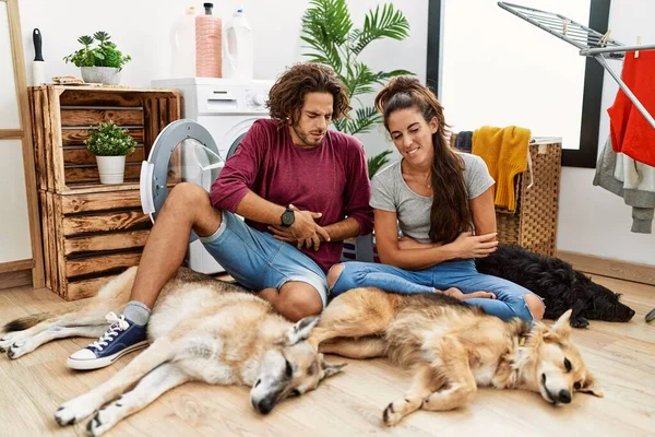 Casal Hispânico Jovem Fazendo Lavanderia Com Cães Com Mão Estômago — Fotografia de Stock