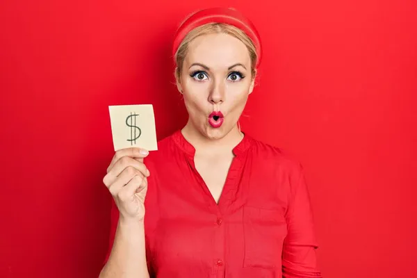 Young Blonde Woman Holding Dollar Symbol Reminder Paper Scared Amazed — Stock Photo, Image