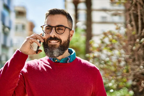 Young hispanic executive man smiling happy talking on the smartphone at the city.