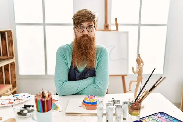 在艺术工作室里 红头发的男人留着长胡子 画着黏土碗 脸上带着严肃的表情 简单而自然地看着相机 — 图库照片