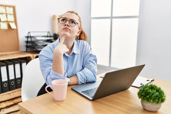 사무실에서 일하고 여자가 컴퓨터 랩탑을 사용하면서 쳐다보는 의심에 집중적으로 합니다 — 스톡 사진
