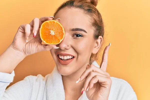 Mujer Rubia Joven Con Albornoz Sosteniendo Naranja Fresca Sonriendo Feliz —  Fotos de Stock