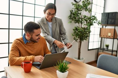 Ofiste masa başında çalışırken gülümseyen iki iş adamı..