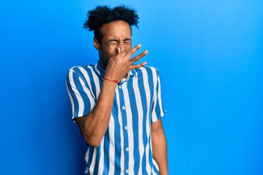 Sakallı, sıradan çizgili tişörtlü, pis ve iğrenç bir koku alan, nefesini burnunda tutan Afro-Amerikalı genç bir adam. Kötü kokuyor. 