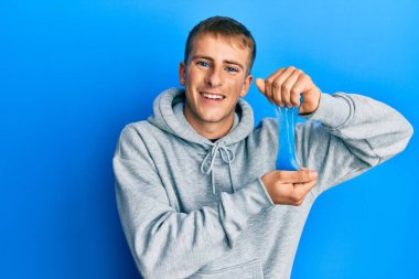 Kafkasyalı genç adam balçık tutuyor ve kahkahalarla gülüyor.. 