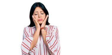 Gündelik kıyafetler giyen genç İspanyol kız. Yorgun eller. Yüzü, depresyonu ve üzüntüyü örten. 