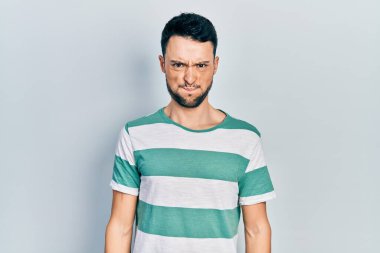 Günlük kıyafetler giyen genç İspanyol adam komik yüzlü yanakları şişiriyor. Havayla şişmiş ağız, çılgın bir ifade.. 