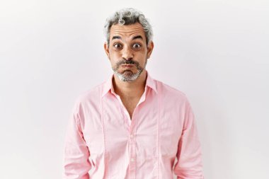 Orta yaşlı, ispanyol bir adam izole edilmiş arka planda durup komik suratlı yanakları tüttürüyor. Havayla şişmiş ağız, çılgın bir ifade.. 