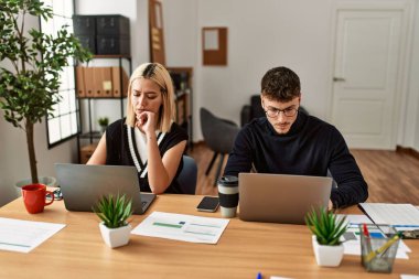 Ofiste çalışan ciddi ifadeli iki iş adamı..