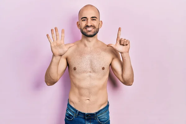 Młody Łysy Mężczyzna Stoi Bez Koszulki Pokazując Wskazując Palcem Numer — Zdjęcie stockowe