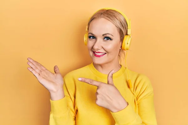 Kulaklıkla Müzik Dinleyen Genç Sarışın Kadın Kameraya Hayret Ediyor Gülümsüyor — Stok fotoğraf