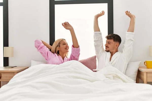 Young Caucasian Couple Waking Stretching Arms Bed Home — Stockfoto