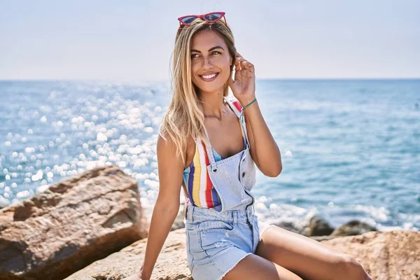 Genç Sarışın Kız Gülümsüyor Kumsaldaki Kayanın Üzerinde Mutlu Mesut Oturuyor — Stok fotoğraf