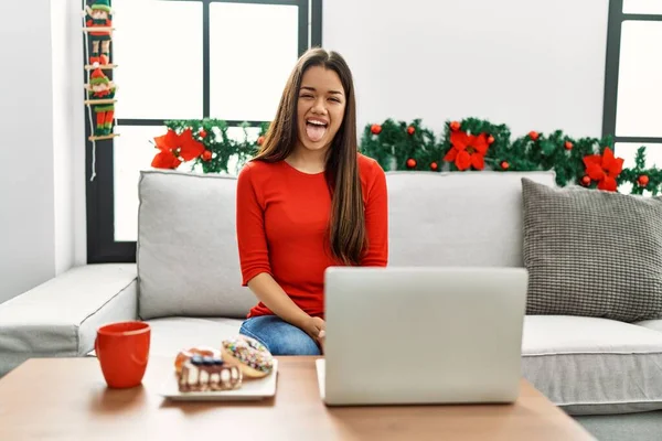 Jovem Morena Usando Laptop Sentado Sofá Natal Colando Língua Feliz — Fotografia de Stock