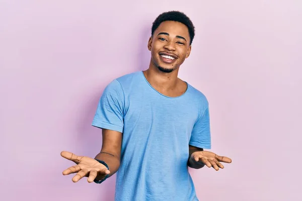 友好的な歓迎 肯定的かつ自信を持って挨拶としてオープン腕で陽気に笑顔カジュアルブルーTシャツを着て若いアフリカ系アメリカ人男性 — ストック写真