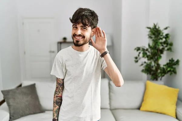 Homem Hispânico Com Barba Sala Estar Casa Sorrindo Com Mão — Fotografia de Stock