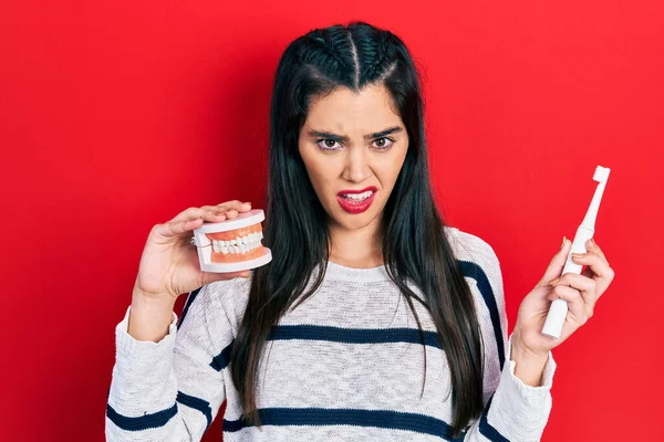 Joven Chica Hispana Sosteniendo Cepillo Dientes Eléctrico Dentadura Postiza Expresión — Foto de Stock