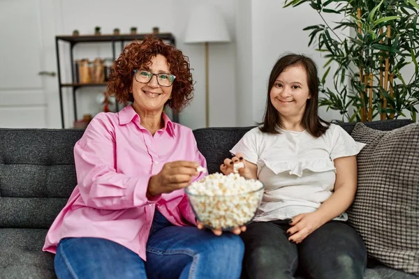 熟女母とダウン症候群娘 ホーム食べるポップコーンとテレビ — ストック写真