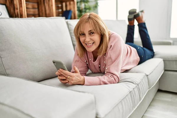 Středního Věku Blondýny Žena Pomocí Smartphone Ležící Pohovce Doma — Stock fotografie