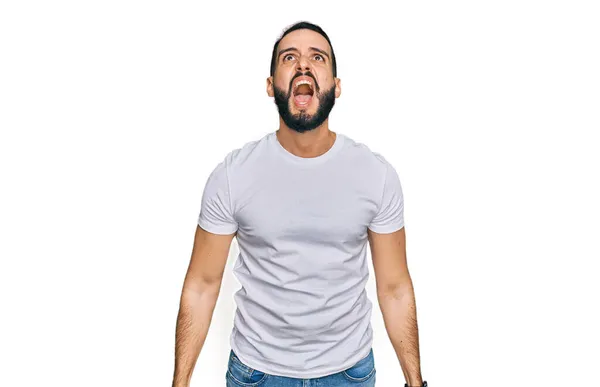 Joven Con Barba Vistiendo Una Camiseta Blanca Casual Enojado Loco —  Fotos de Stock