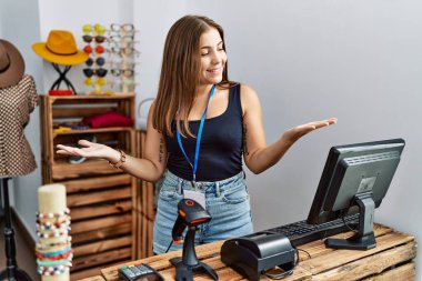 Genç esmer kadın perakende dükkanında açık mesajla pankart tutuyor. Gülümsüyor, avuçlarını açıyor, sunuyor, reklam yapıyor, karşılaştırıyor ve dengede duruyor. 