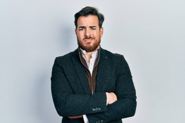 Sakallı, kolları çapraz hareketli, kafası karışık yakışıklı beyaz bir adam. şüphe kavramı. 