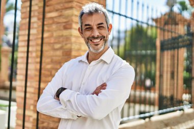 Orta yaşlı, kır saçlı, mutlu gülümseyen bir adam..