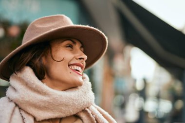 Şık giyinen genç İspanyol kadın şehirde dikiliyor..